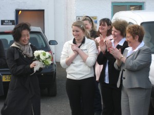 The Laddie Lasses congratulate the lucky Japanese tourist who took home the bridal bouquet.
